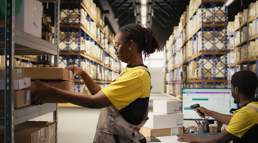 Two logistics workers managing inventory in a large industrial warehouse