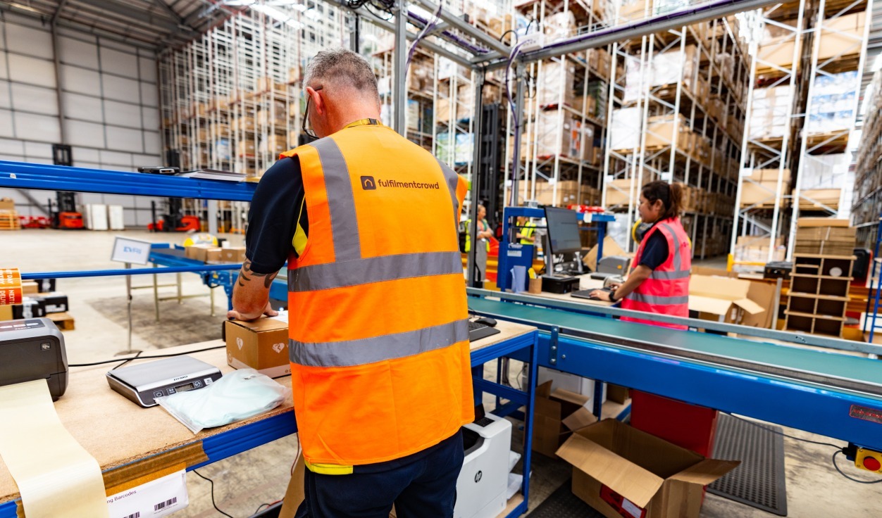 A fulfilmentcrowd worker packing a box in one of our warehouses